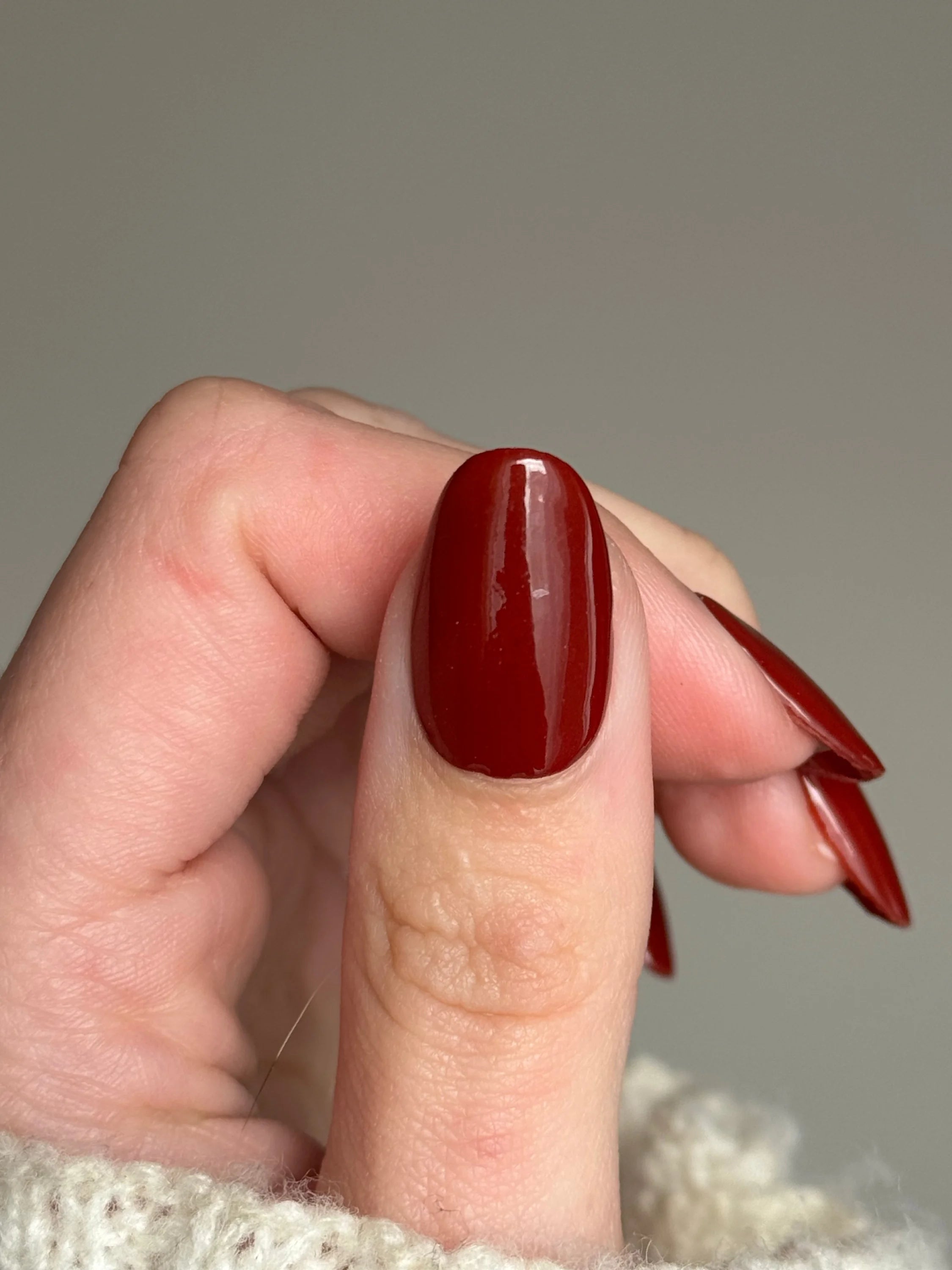 Bordeaux rode dipping powder op lange amandelvormige nagels met diepe rode glanzende nagellak