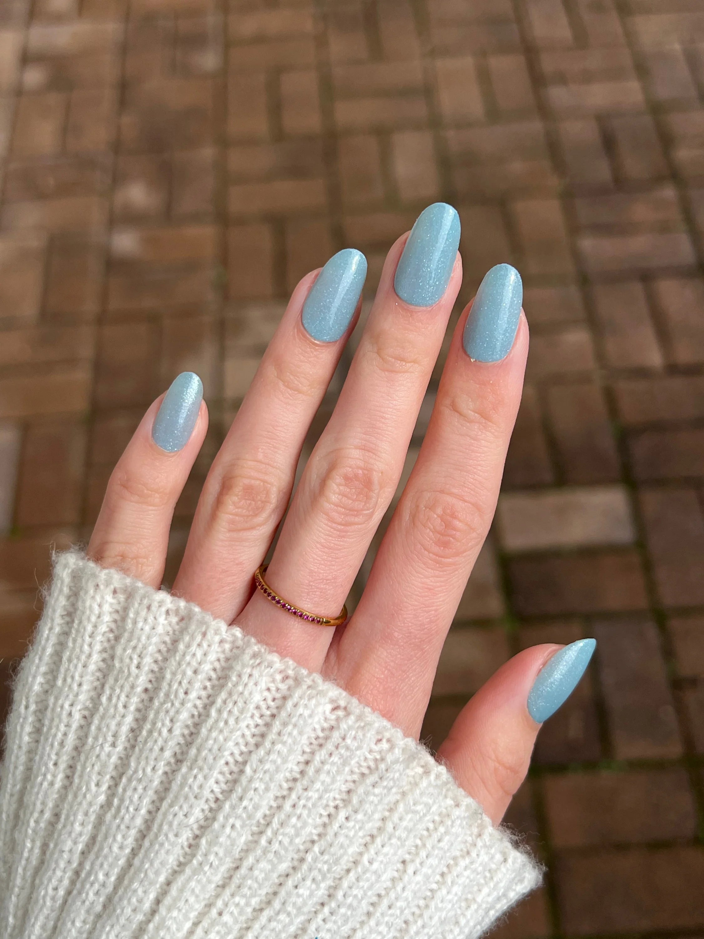 Lichtblauwe glanzende nagellak op netjes verzorgde vingers met mystic lagoon dipping powder