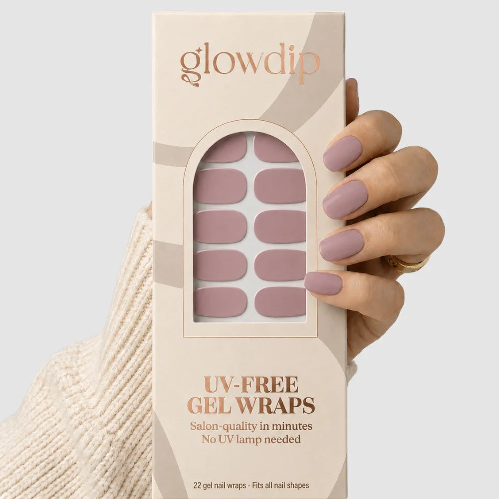 Een hand houdt een doos glow dip uv-free gel wraps met zachte mauve nageldecoraties in de nude blush kleur
