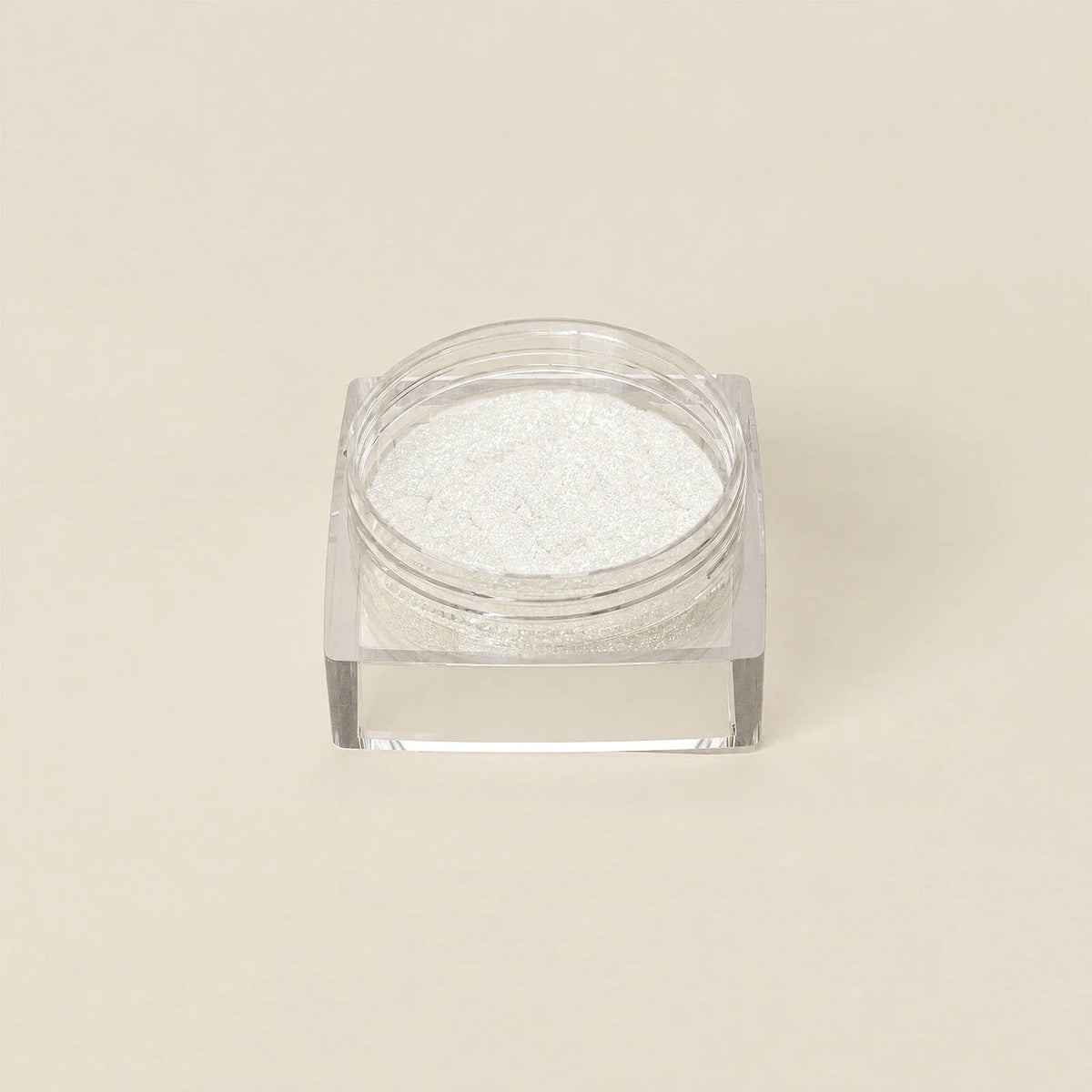 Een doorzichtige vierkante container met glinsterend wit goudkleurig shift chrome poeder