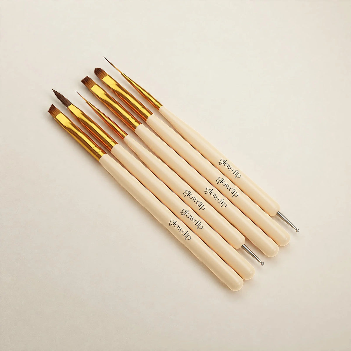 Set van zes crèmekleurige nagelkunst penselen met gouden ferrules en diverse borsteltips voor nail art