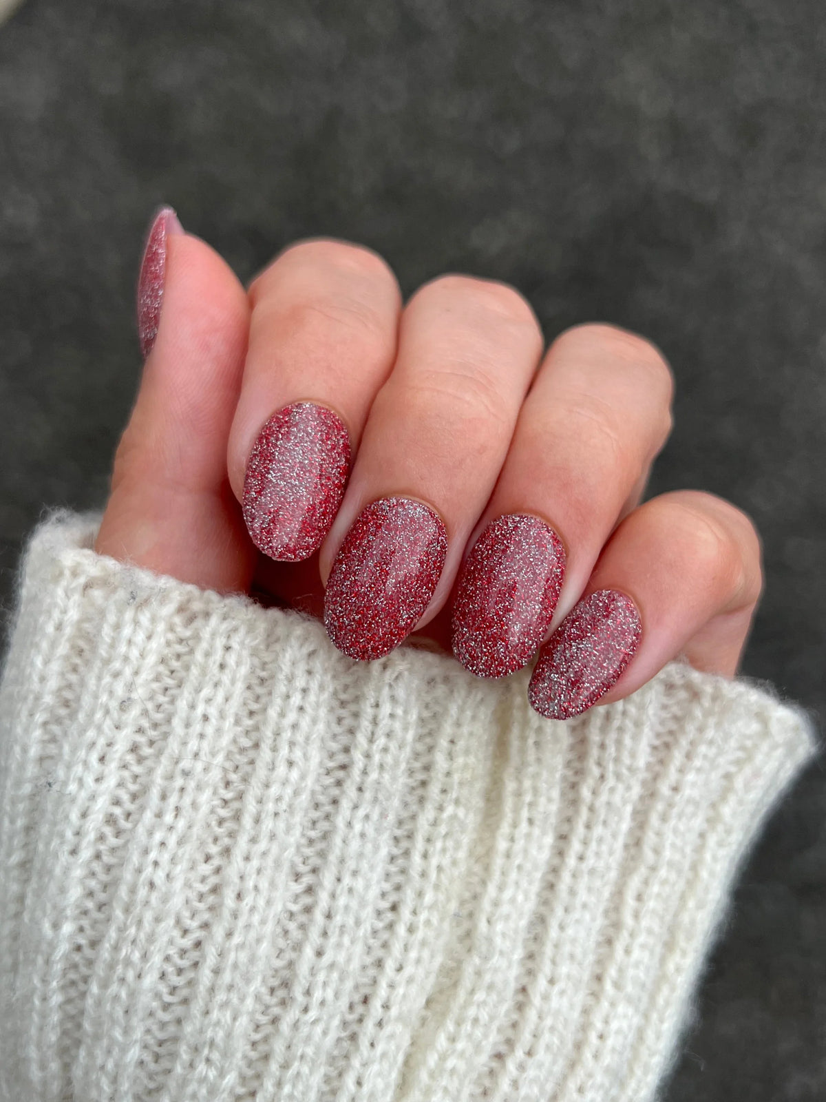 Hand met nagels gelakt in limited edition 11 fire flash glinsterende rode dipping powder polish