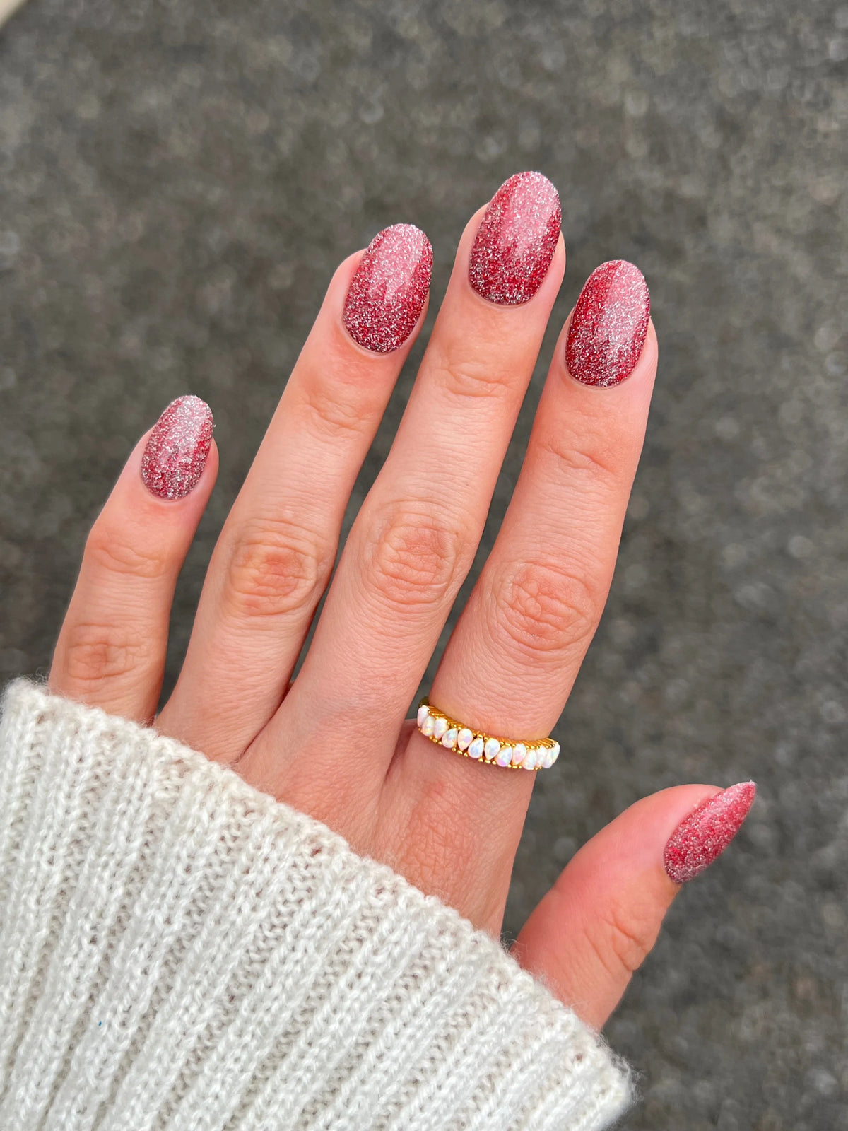 Een hand met lange, ovale nagels in een schitterende gradient van dieprood en roze glitter limited edition 11 fire flash dipping powder