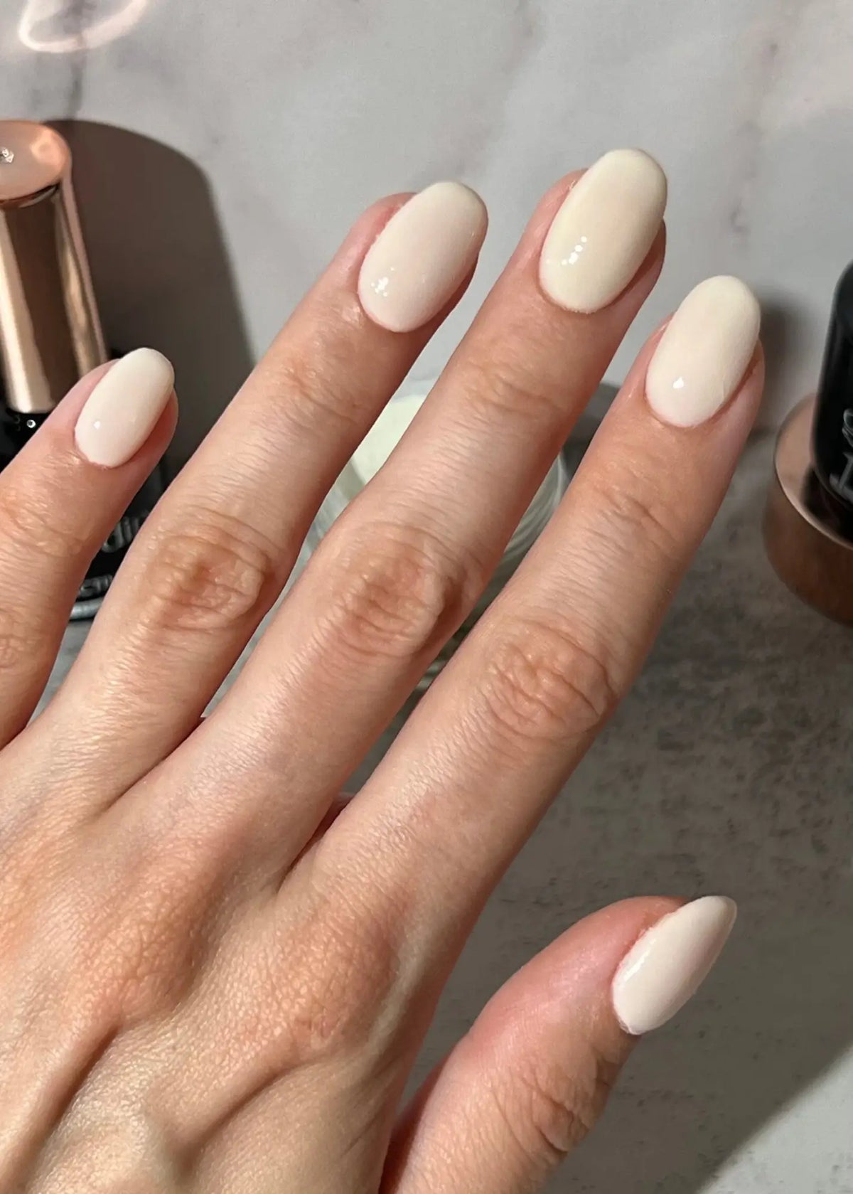 Hand met netjes gelakte dipping powder nagels in glanzende roomwitte kleur zonder uv-lamp gebruik