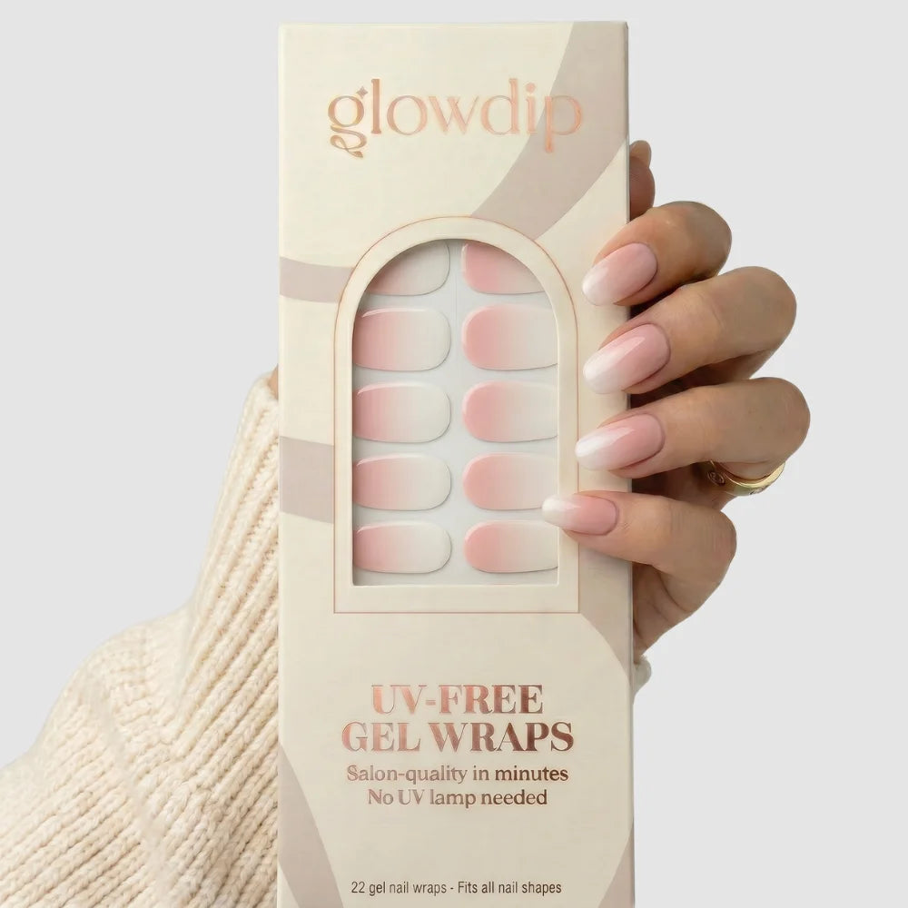 Een hand houdt een doos baby boomer glow uv-free gel wraps met roze-witte ombre nageldecoraties