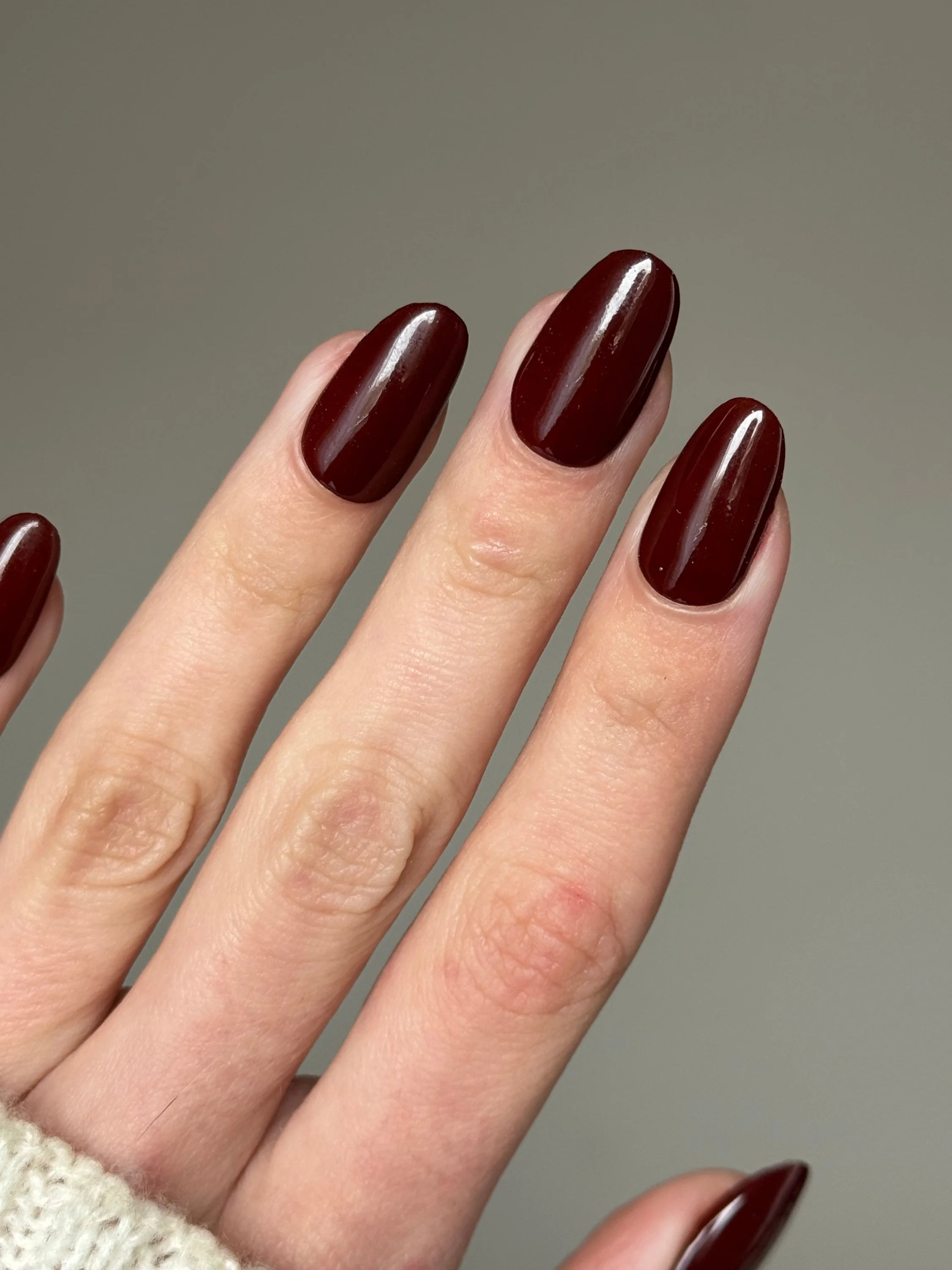 Diep bordeaux glanzende nagels met ovale vorm gemaakt met dark chocolate dipping powder