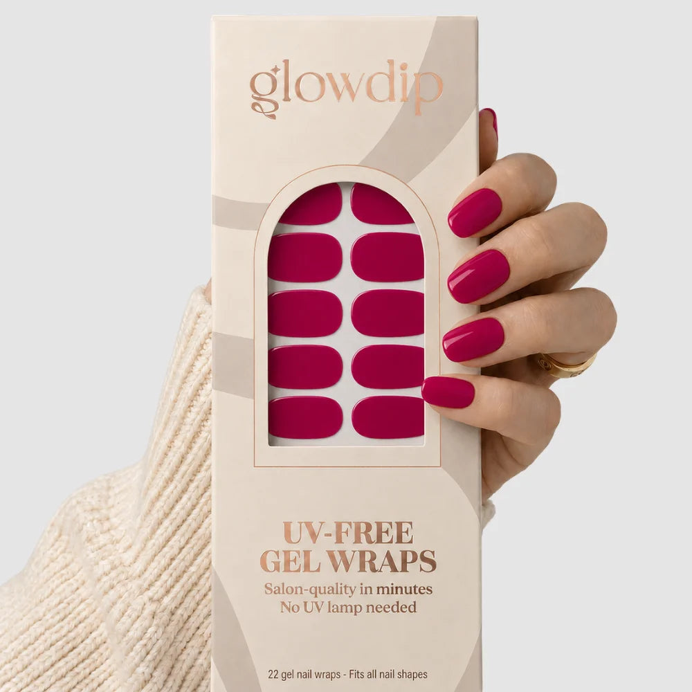 Een hand houdt een doos glowdip uv-vrije gel nagelwraps in fel fuchsia met 22 salonkwaliteitswraps voor alle nagelvormen