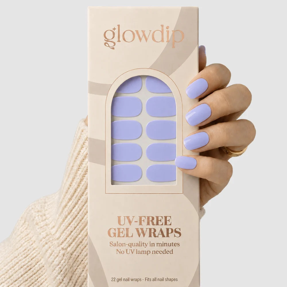 Een hand houdt een beige doos met glowdip uv-free gel nagelwraps in lavendel mist kleur en ovalen vorm