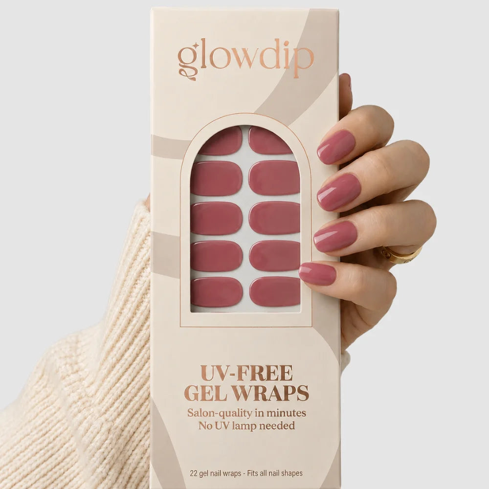 Een hand houdt een doos glowdip uv-vrije gel nagelwraps in zachtroze met 22 salonkwaliteit wraps voor alle nagelvormen