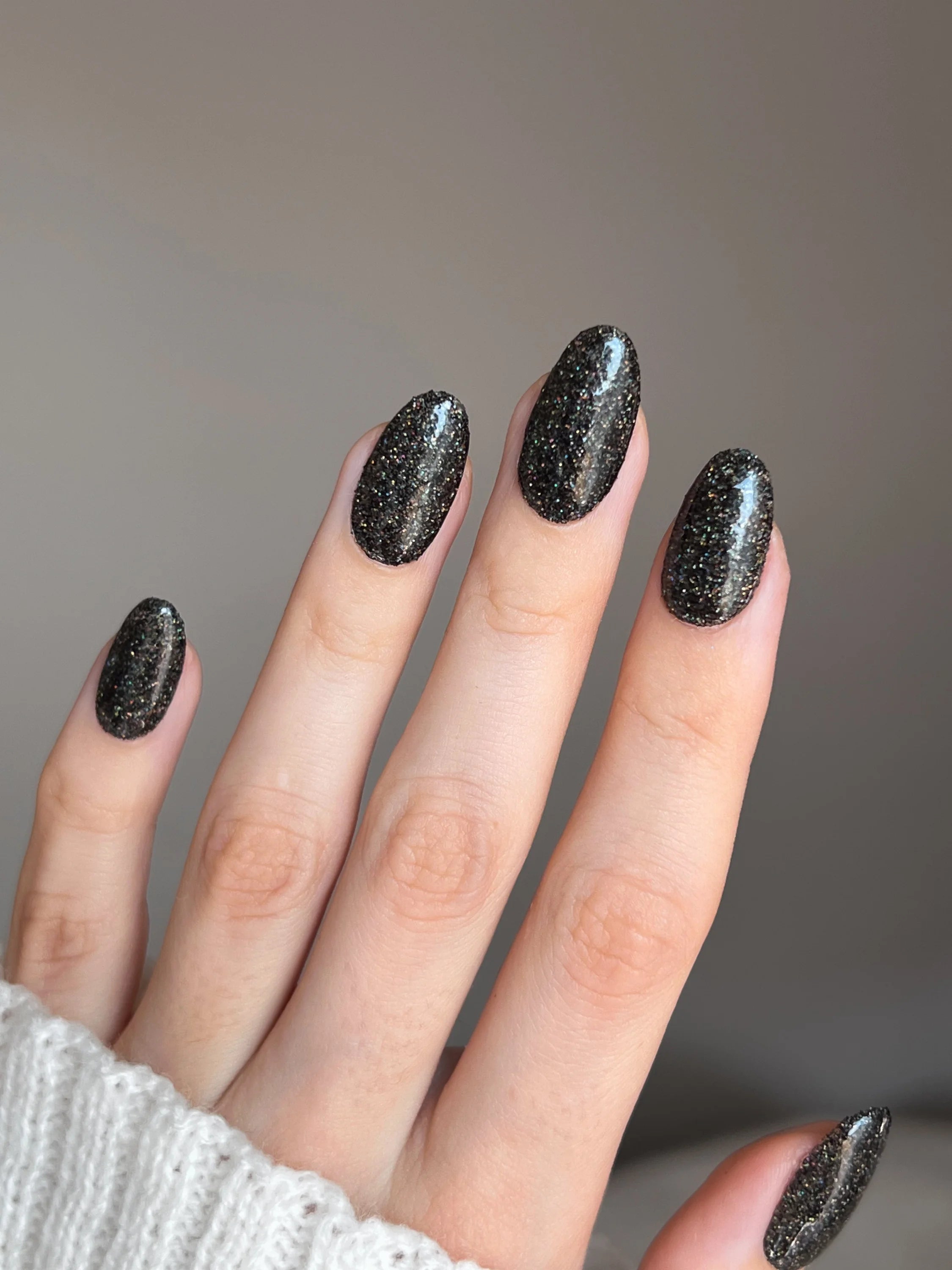 Black glitter dipping powder nail polish with shimmering sparkling finish in black out color