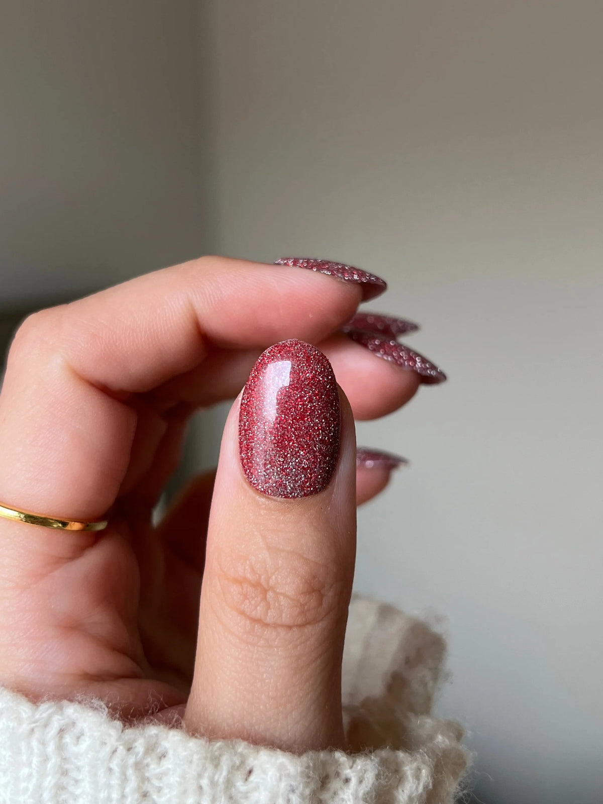 Een hand met nagels gelakt in een limited edition 11 fire flash diep rode glitter dipping powder