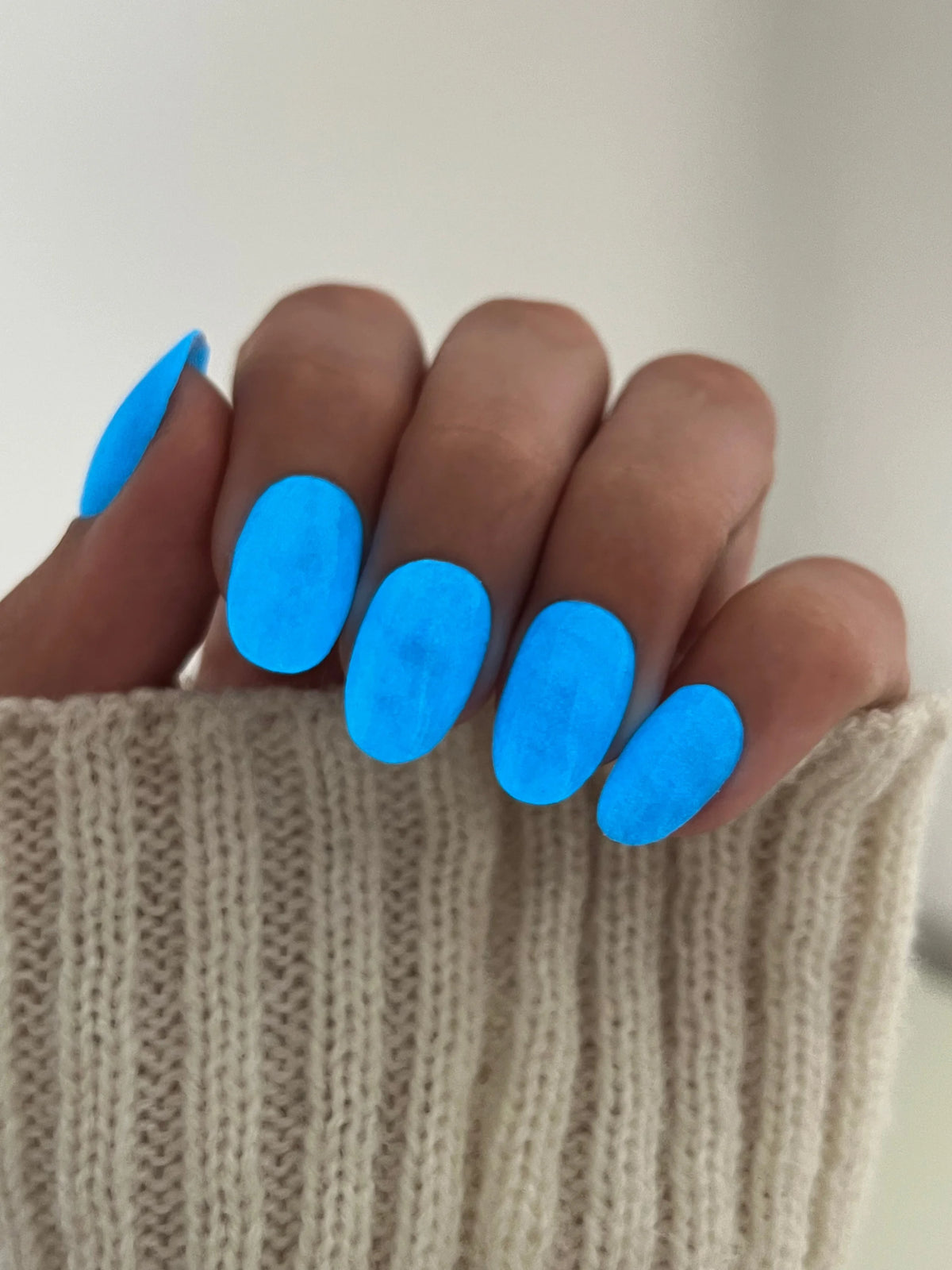 Helderblauwe glanzende nagellak op netjes verzorgde nagels met limited edition 10 moon glow dipping powder