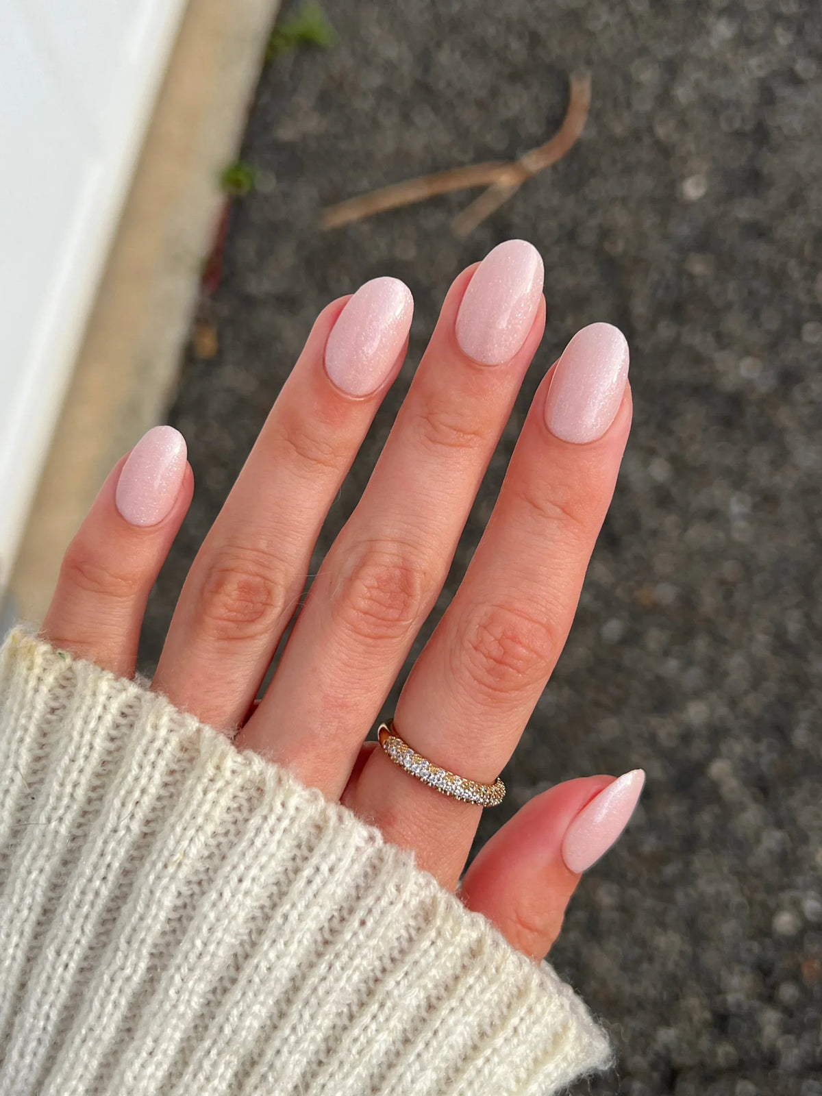 Hand met lange amandelvormige nagels in zachte matte roze nagellak passend bij herfst bundel